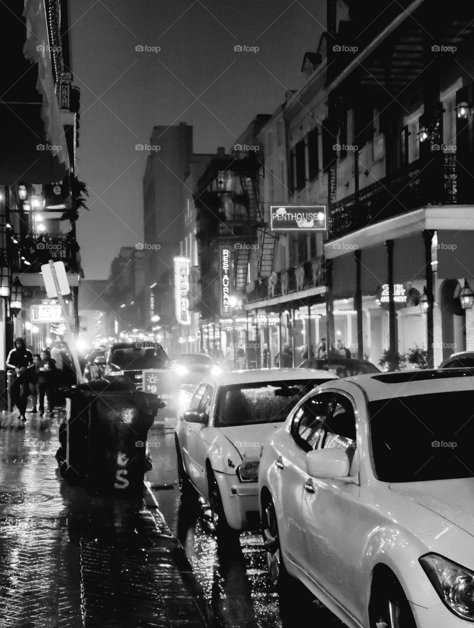 Rain soaks a downtown street creating reflections on the soaked roads and sidewalk