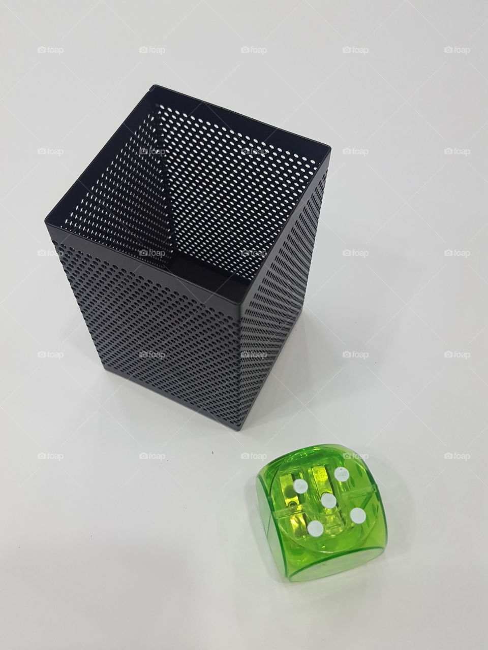 Black perforated metal pen stand with green dice themed pencil sharpner
