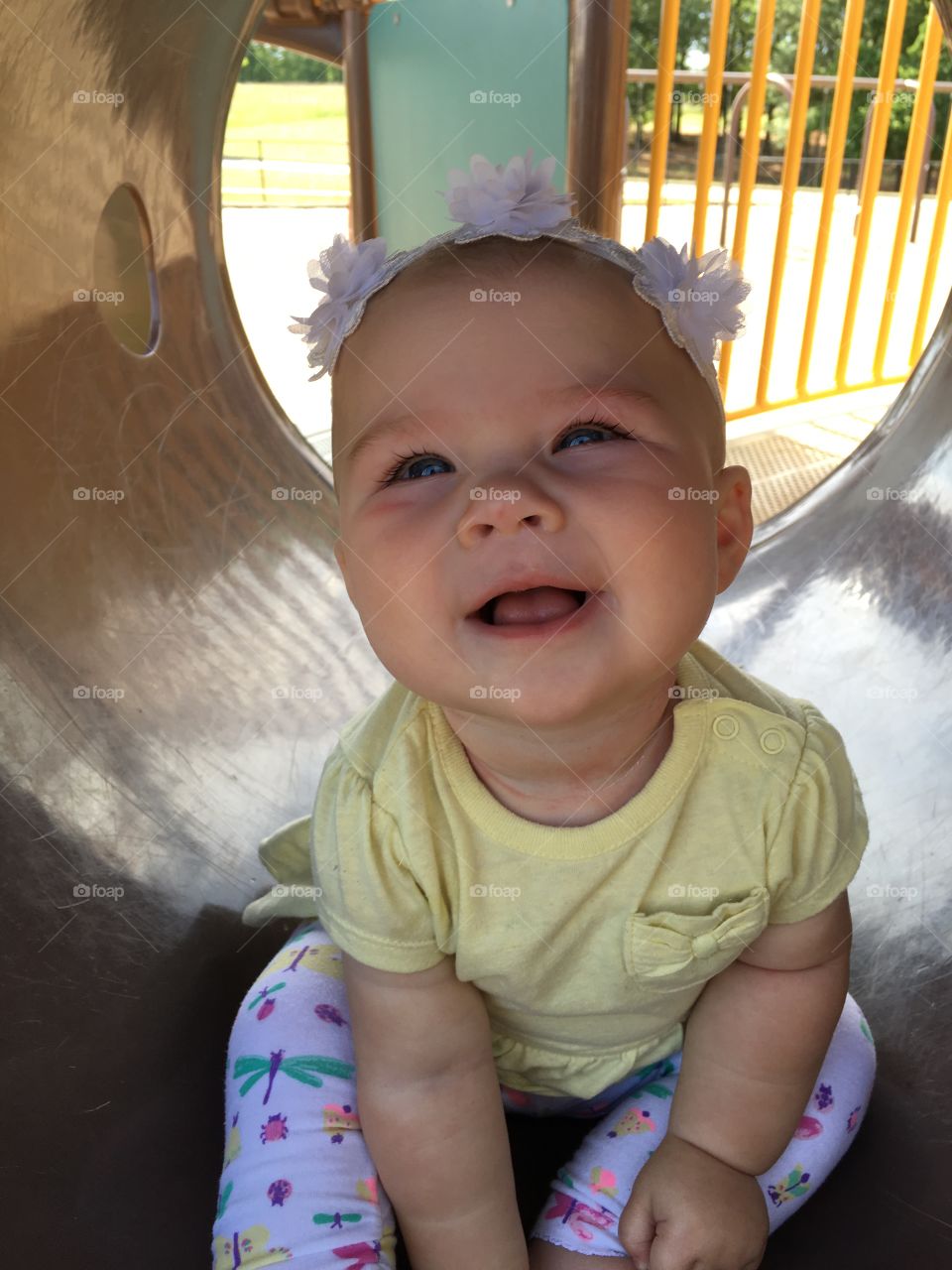 Toddler girl sitting in tunnel at playground