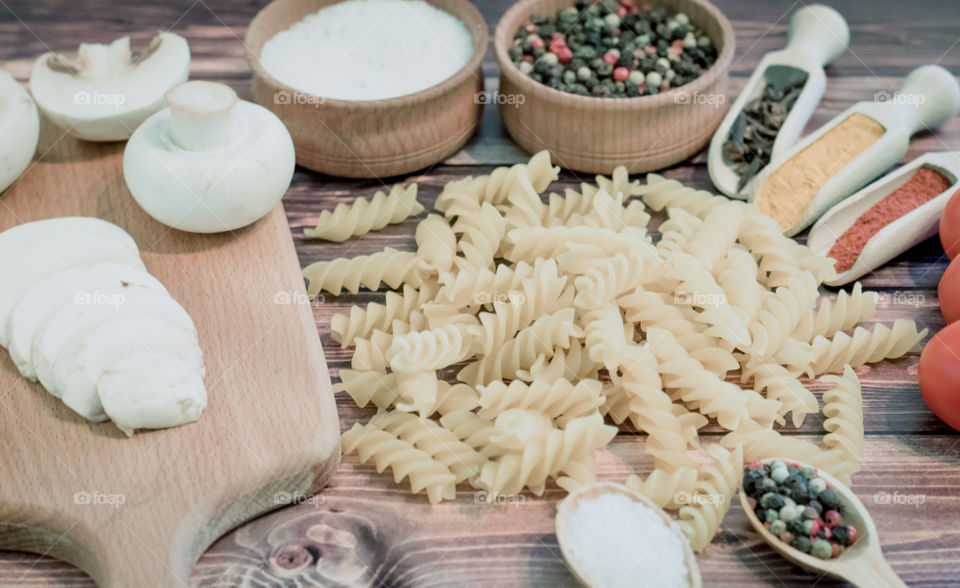 Raw pasta with ingredients and wooden accessories