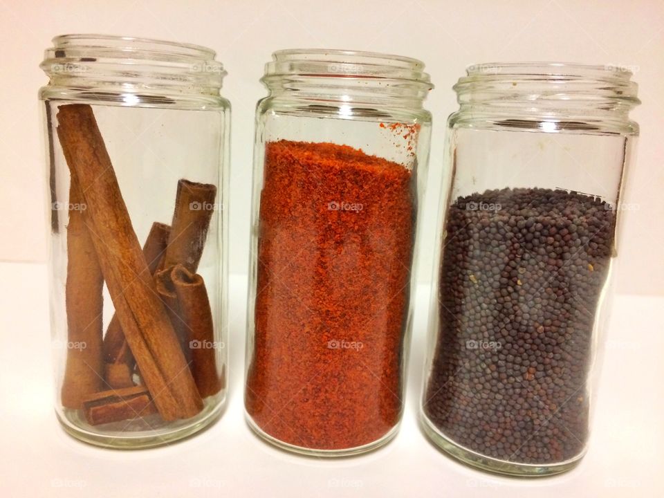 Three dry condiments in glass jars 