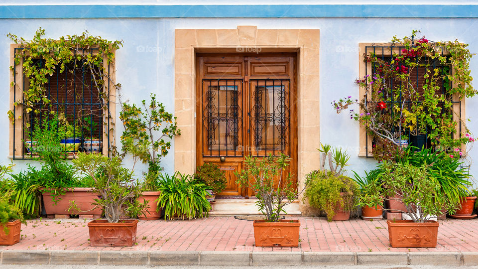 Pots and plants in front of house.