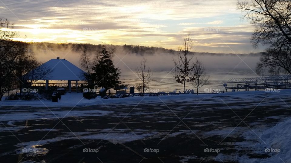 Fog rolling of a frozen lake in earlier morning on a cool crisp Wisconsin morining, in the middle of winter.