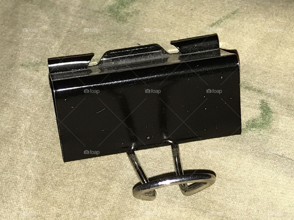 A homemade smartphone stand. The binder clip is repurposed by being converted into this useful device.