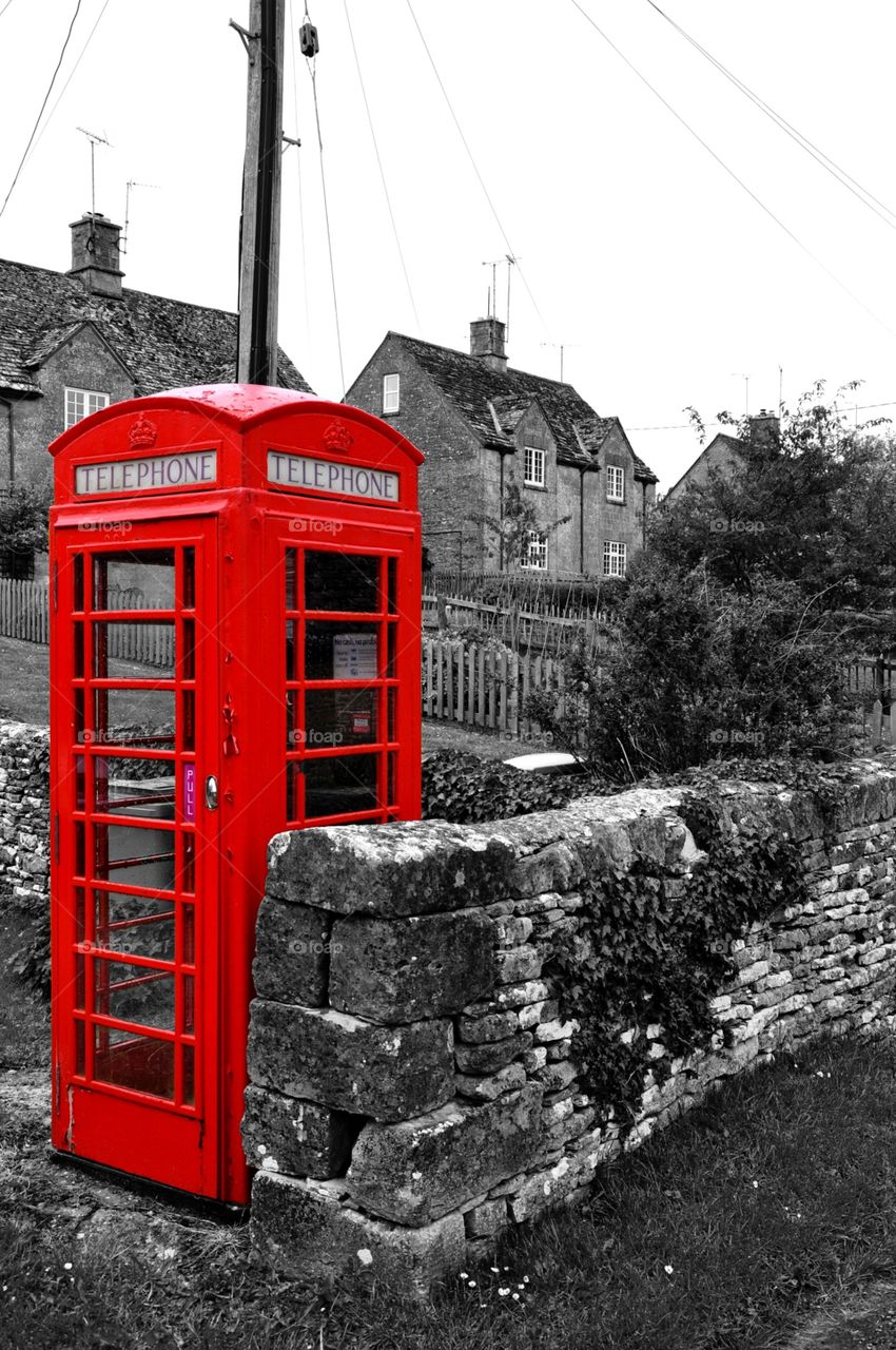 Telephone booth in the cotswolds in B&W and red