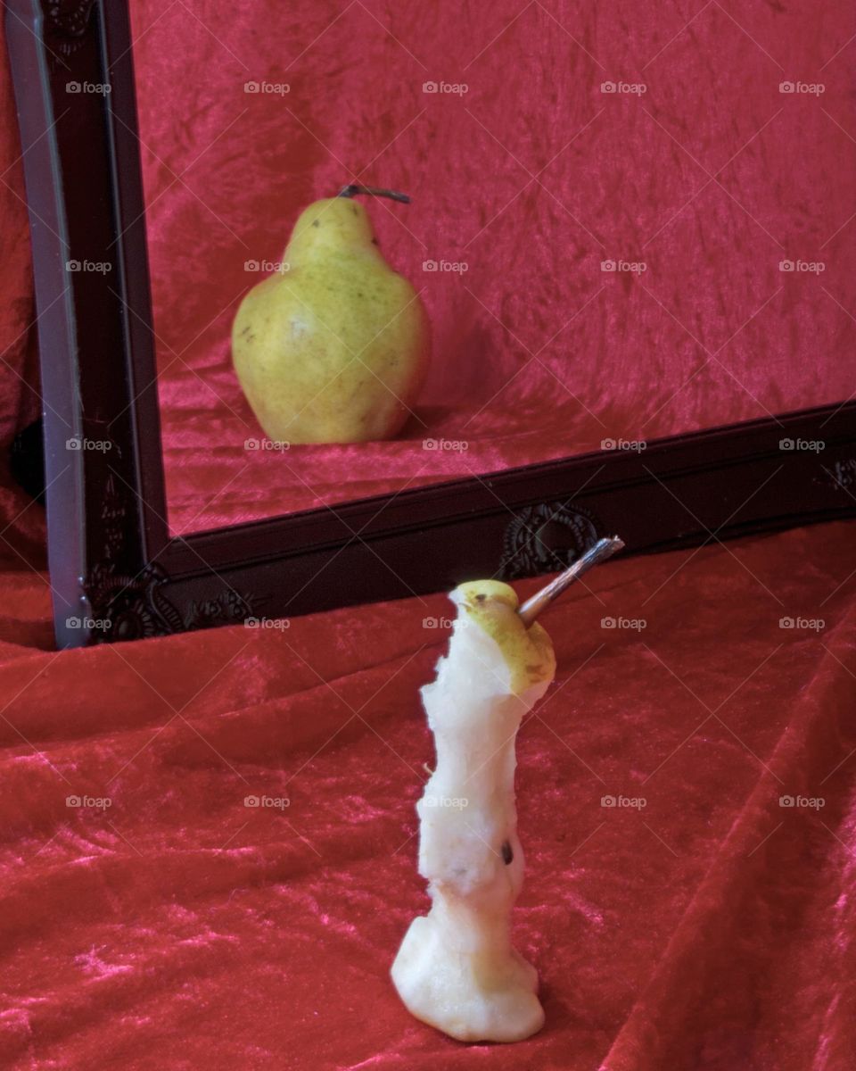 Symbolic of anorexia,  skinny eaten pear sees itself as a very plump pear 