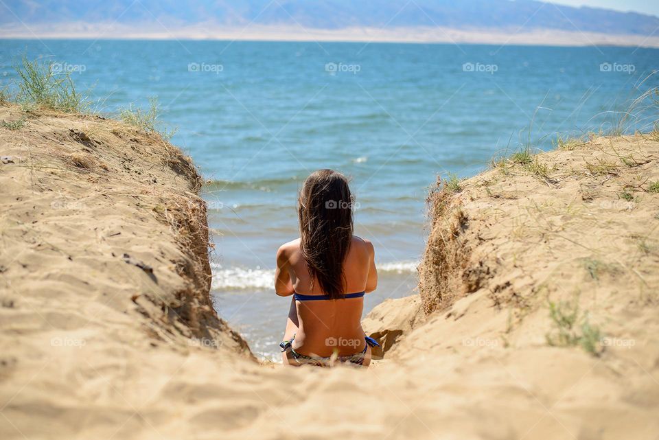 Woman sitting on the sandy beach