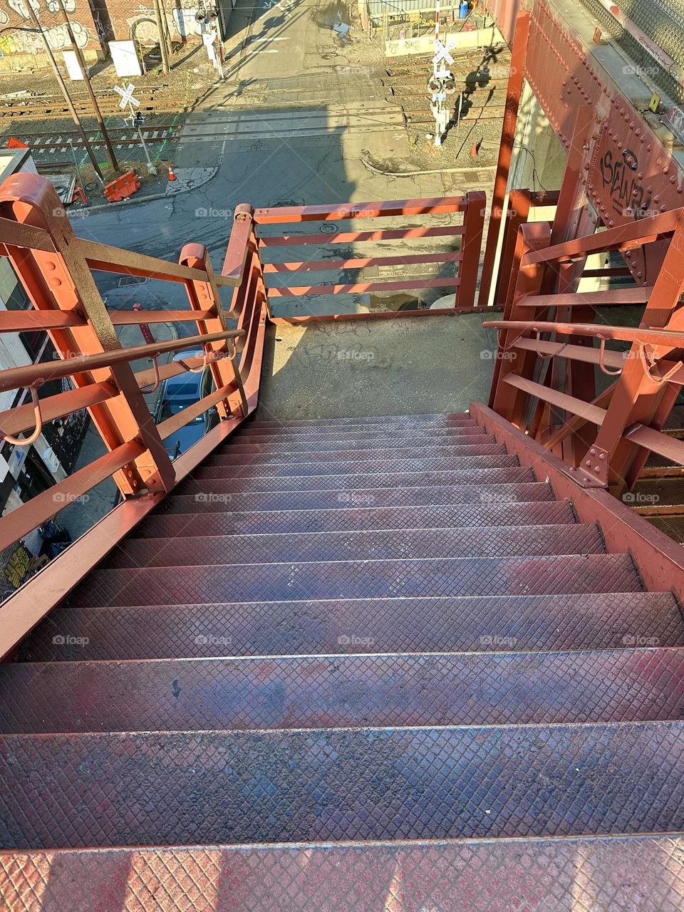 This is the descending red metal staircase of the “Pulaski Bridge” at “Newtown Creek” in LIC, Queens showing interesting shadow patterns. 2023. Hypnotic Productions