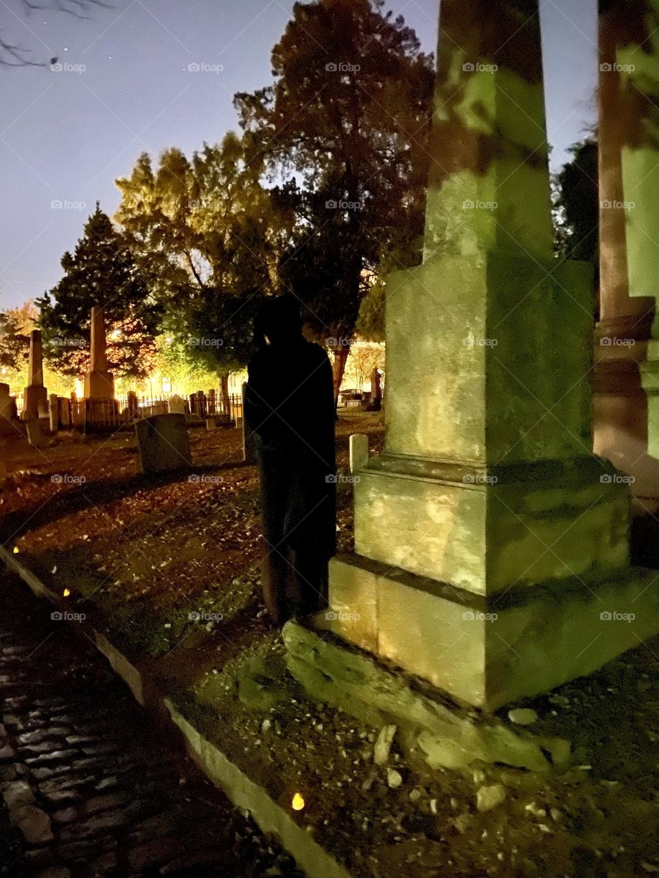 Cloaked figure by gravestone night spooky 