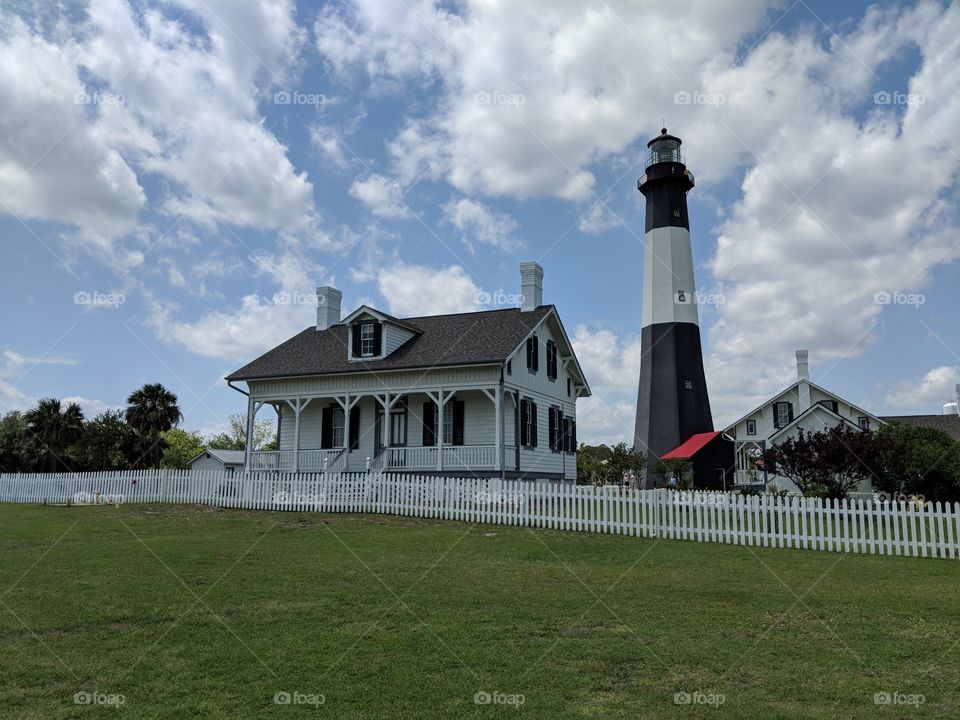 lighthouse with house in a cloudy day