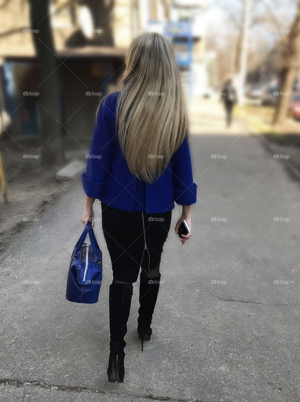 Young blonde woman with long hair walking in the city 