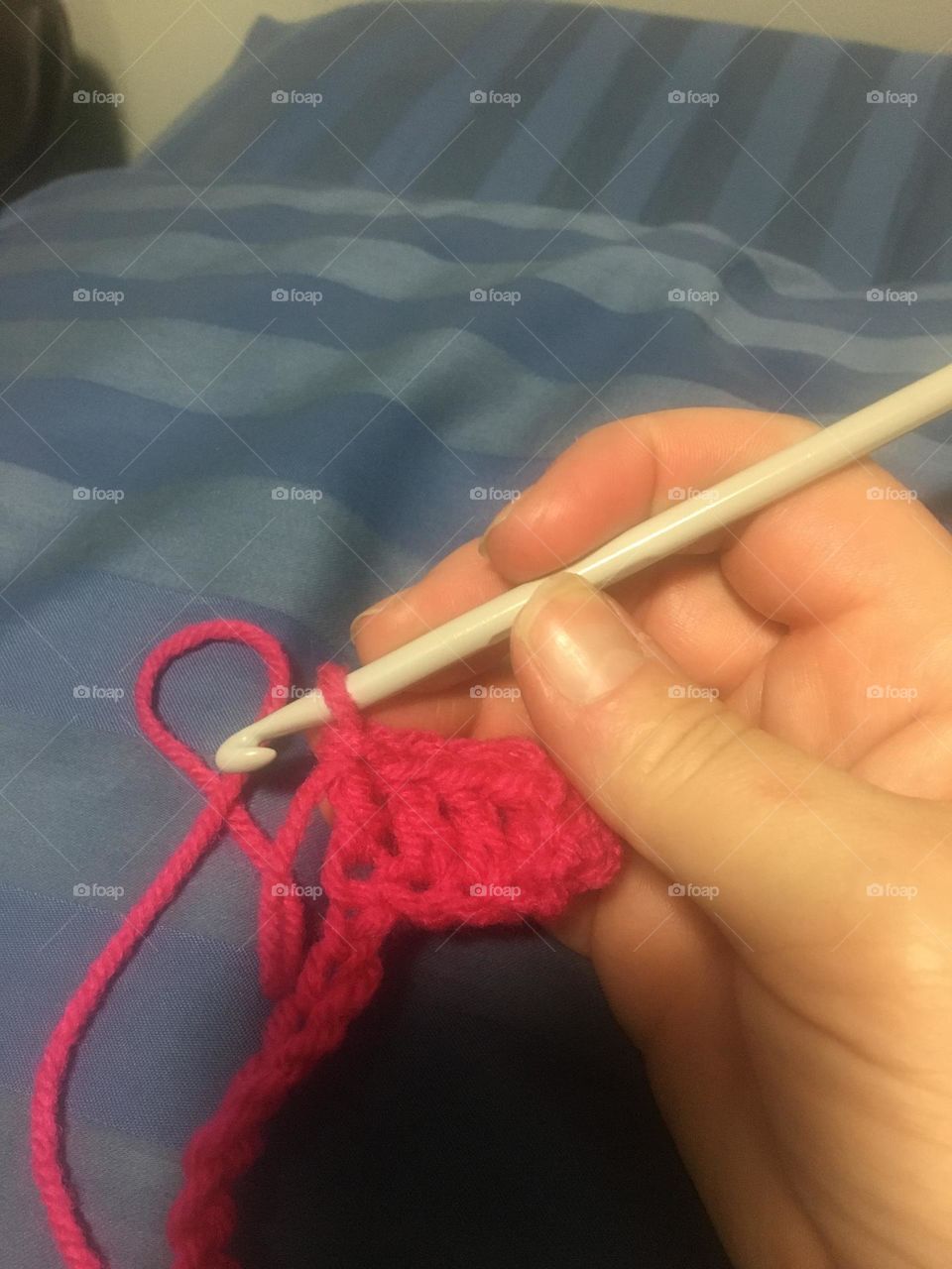 Middle aged lady, crochetting a red afghan 