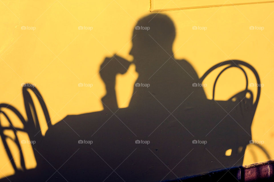 Vibrant silhouette of a person drink coffee in the morning sun