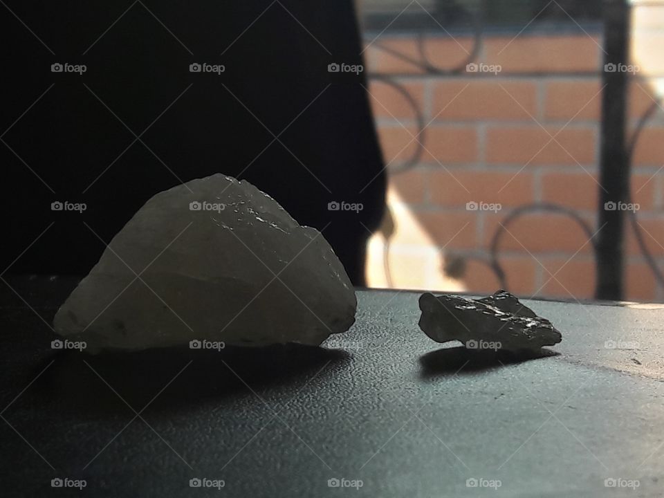 Piedras en la mesa negra con pared de ladrillos de fondo