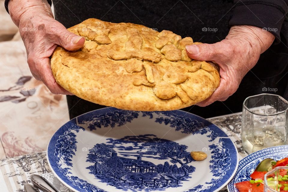 Grandma’s hands break the Christmas bread