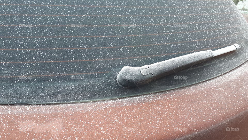 Rear windscreen of car with wiper coverd in a blanket of frost.