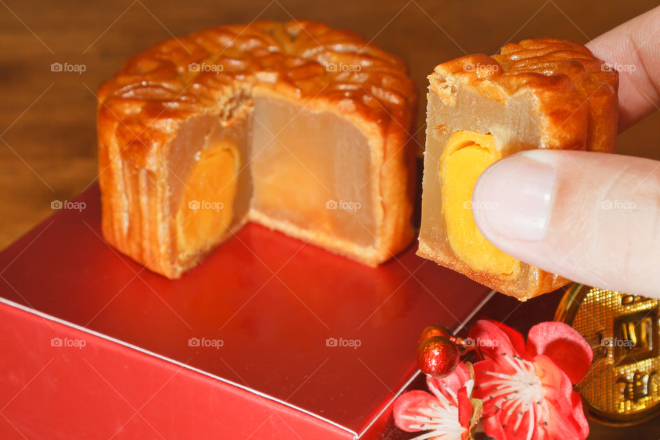 Close up of a hand taking a piece of a freshly baked moon cake