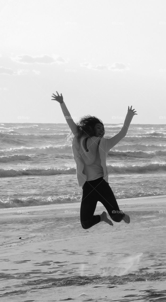 Jumping for joy! 
Girl on the sandy beach of the Gulf of Mexico, jumps for joy!