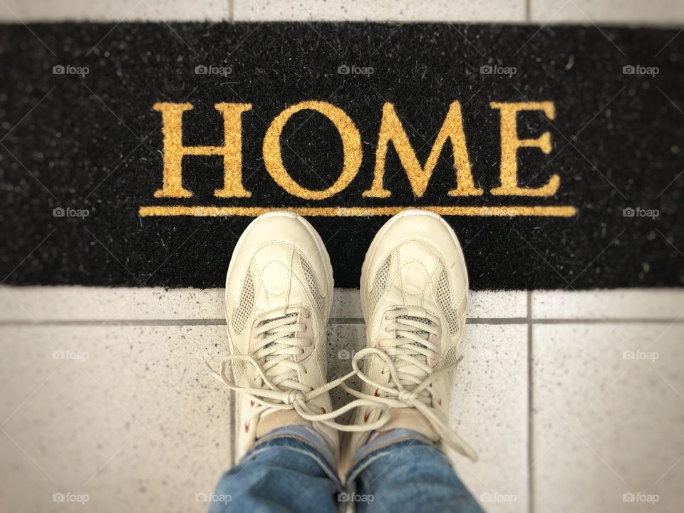 White sneakers on a doormat of a new house