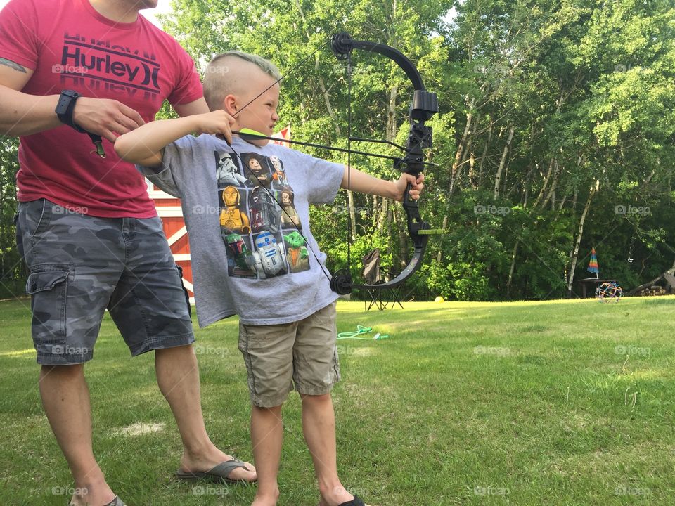 Man teaching his son archery