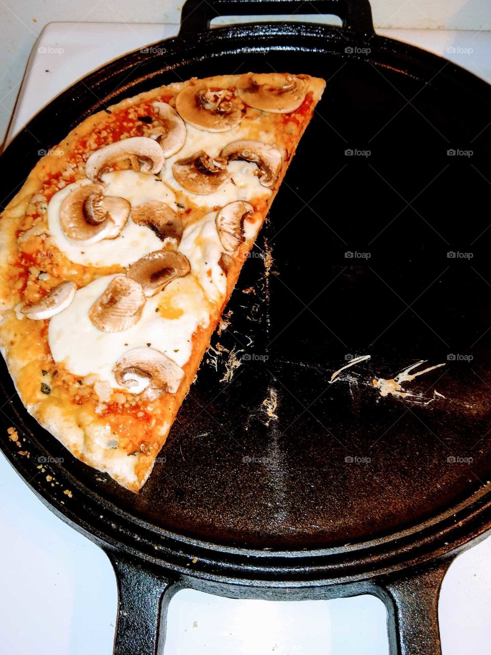 Pizza Margherita with fresh sliced mushrooms, heated on cast iron skillet