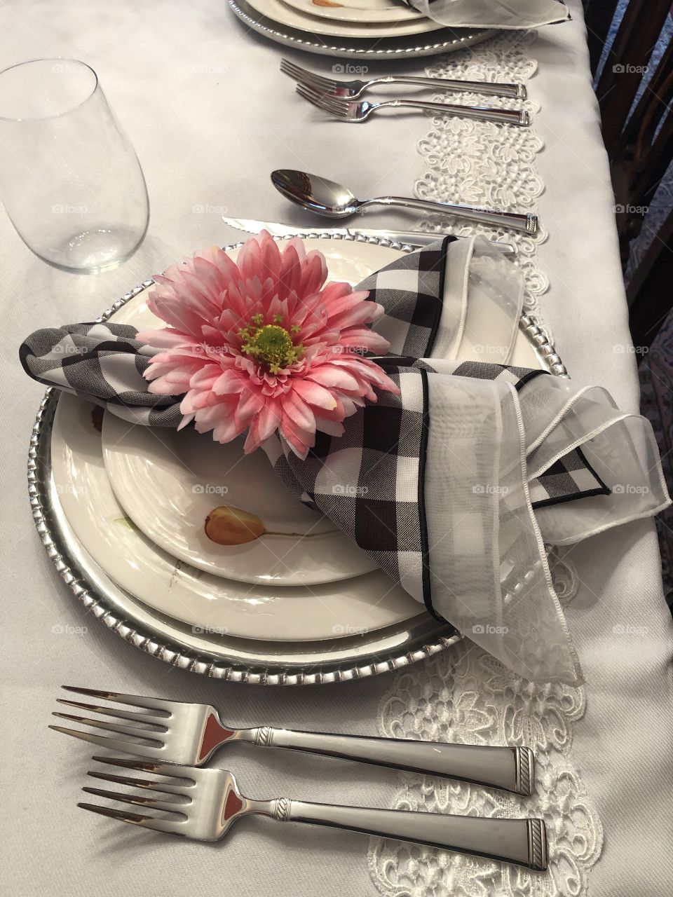 Place setting on the dining room table with flower napkin ring