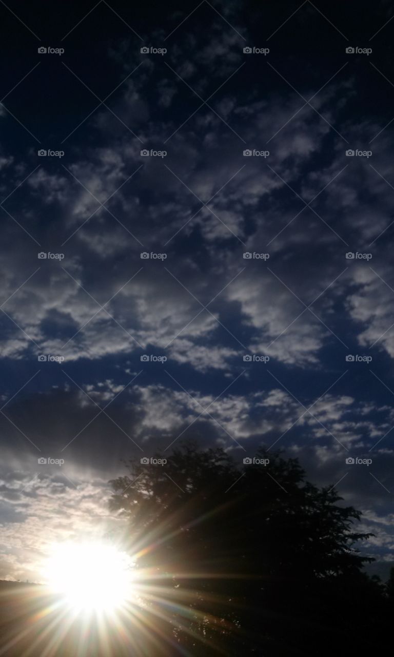 Here is a question, is it night or day, evening or morning? 
Believe it or not, it is a sunset evening.   I tapped my phone to 
focus, and snapped as quick as 
my  finger could snap the moment.
This photo reminds me of a Amarillo, Texas tornado warn in . 
I was in the second grade, and 
me and my classmates witnessed 
night appear suddenly , from a 
sunny beautiful day.
  Instantly we all were told to get
under our desks, ( i think about that today, and i cannot imagine
how that little desk of mine, was going to save me from a Tornada 
whisking me off to some other
Texas town.
  How neat it is when pictures 
remind me of other adventures.
Or past situations, like the one 
i just mentioned.  Anyone that is 
living where the heat index has
been blistering, seeing clouds in 
the skies, are a delightful sight
to see after months of no rain,
and over 100° just a bit exhausting.  This has become one 
of my favorites that i have taken.
Pictures  say a thousand plus a
thousand words.
the colors, skies, sun