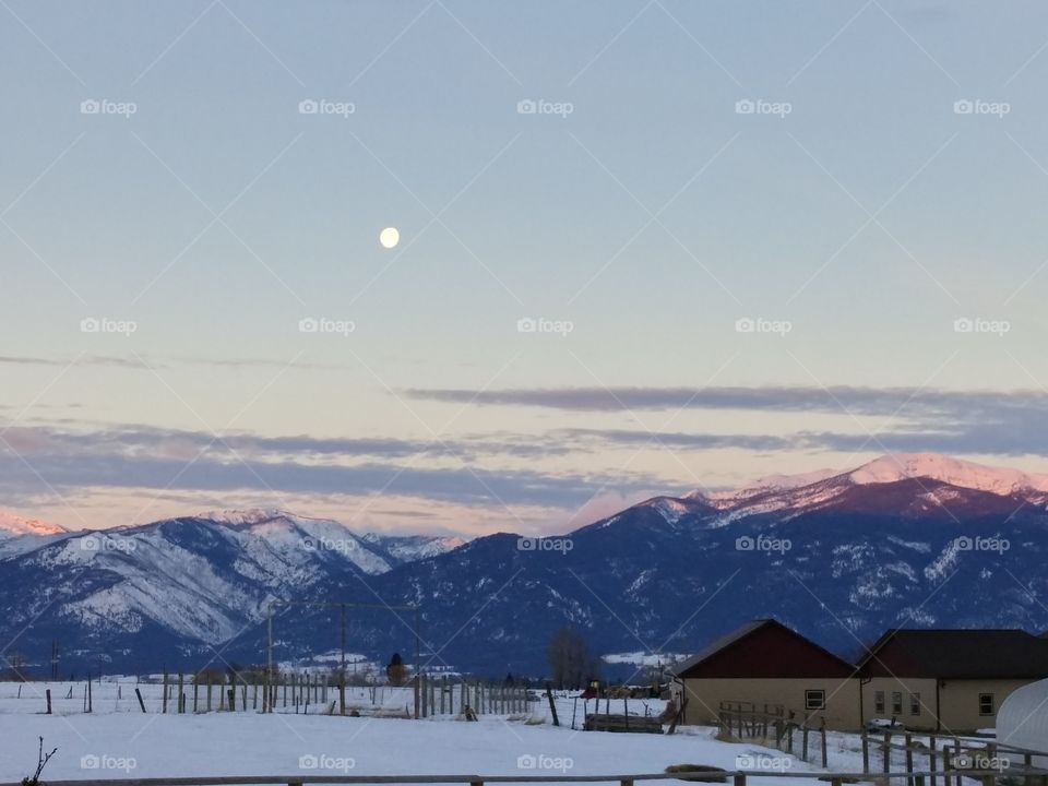 Full moon over mountains at dawn