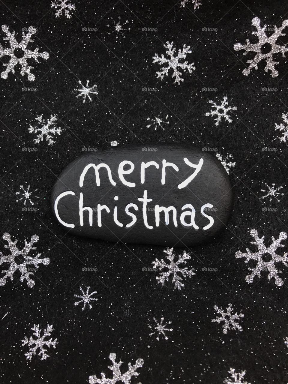 Merry Christmas on a black painted stone