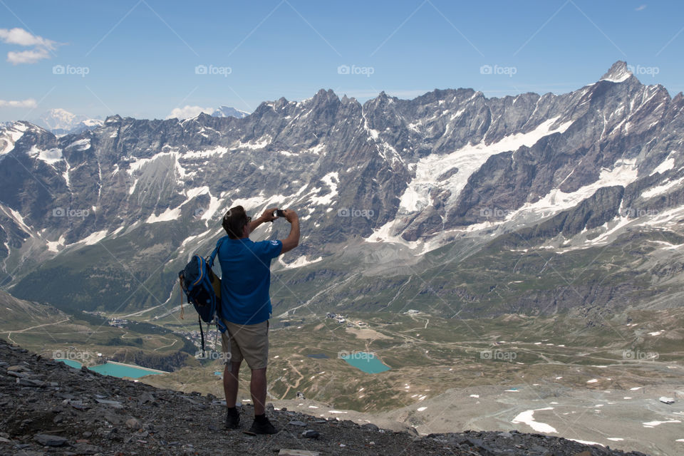Man taking pictures from Plateau Rosa, Beautiful view of Breuil-Cervinia Aosta Valley Italy, fantastik utsikt över Cervinia Italien, Italia 