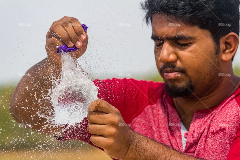 Man bursting balloon filled with water