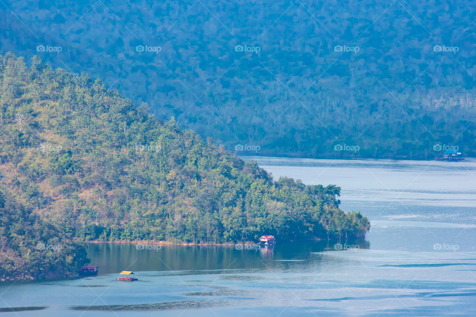 The beauty inside the dam and the houseboat on the bright sky at Sri Nakarin dam , Kanchana buri in Thailand.