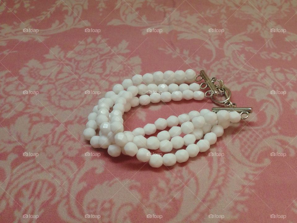 White bracelet on pink background 