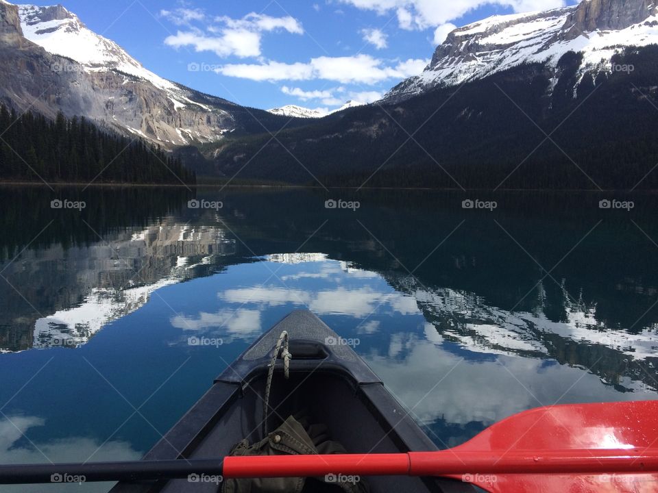 Red oar on boat in emerald lake