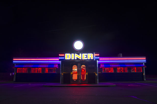 A brightly lit American Diner with neon lights at night