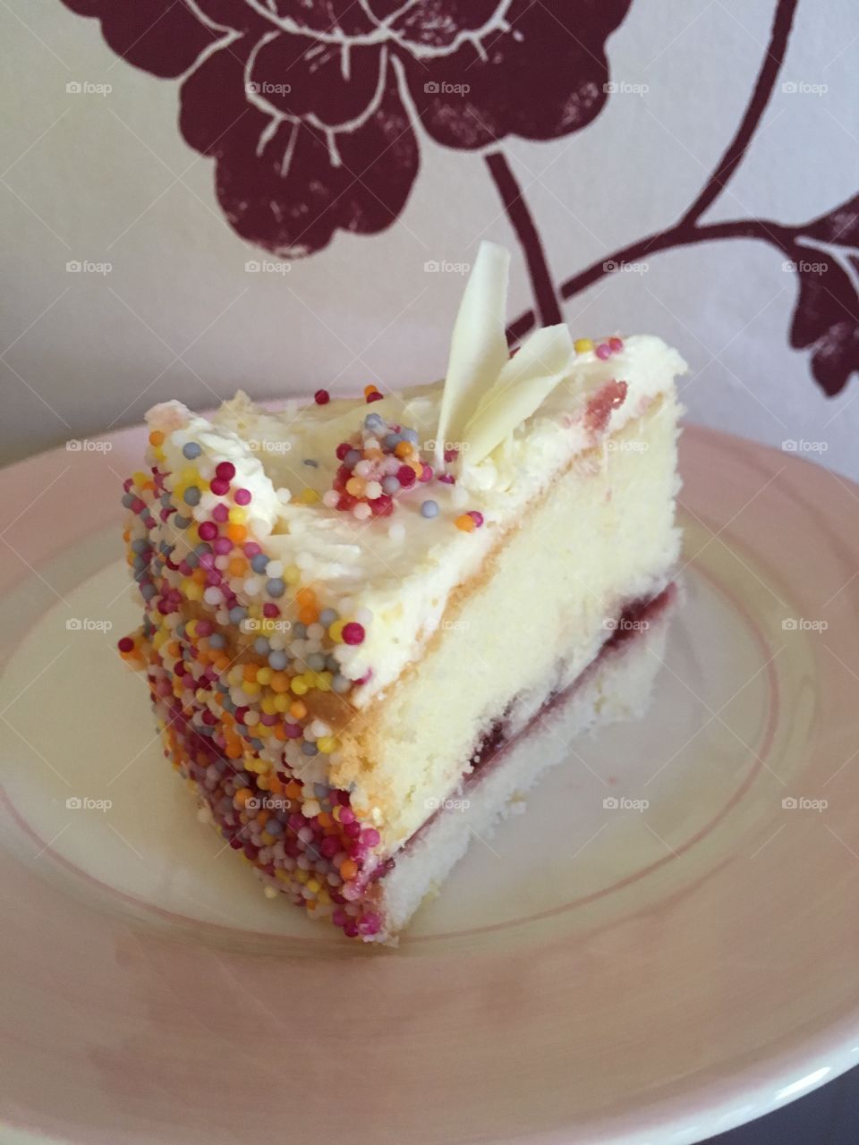 Close up view of vanilla gluten free sponge cake and frosting with sprinkles 