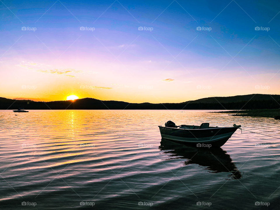 Boat anchored on shore of a lake 