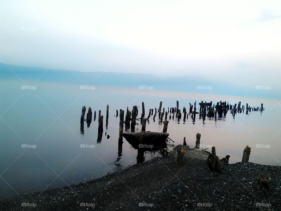 Abandoned wooden bridge at the lakeside 