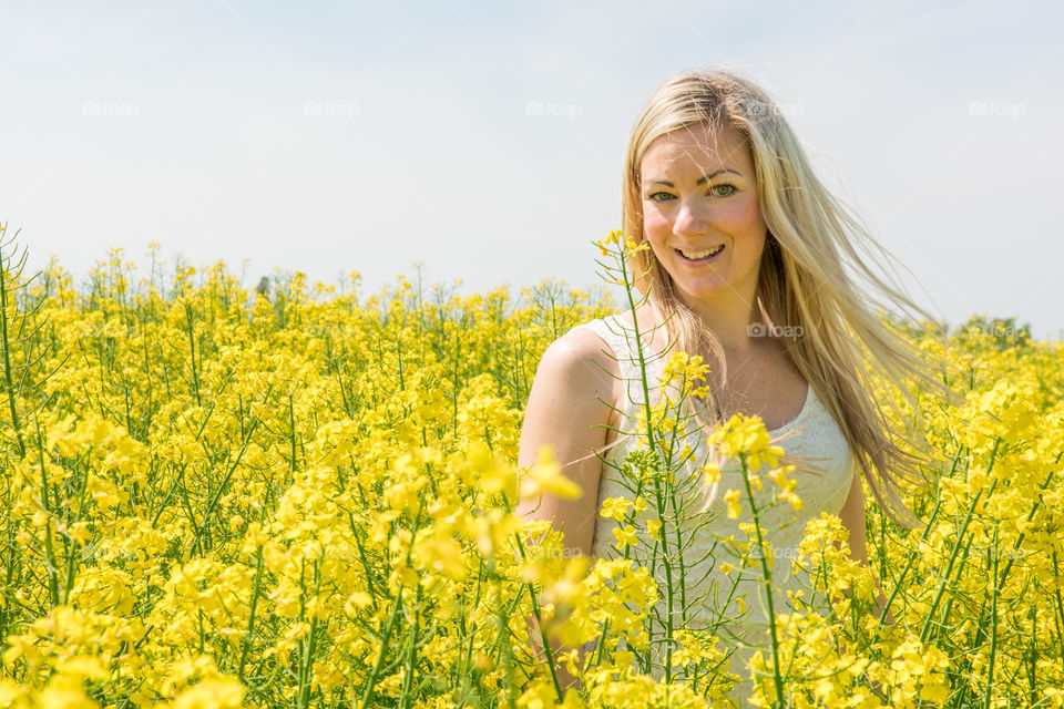 Woman 30 years old walking in a Raps field outside Malmö in Sweden.