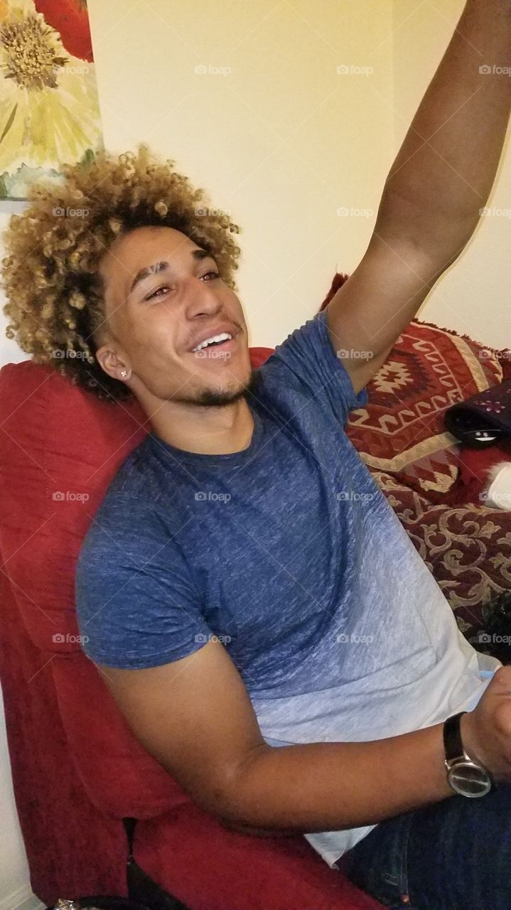 happy biracial young man with blonde afro