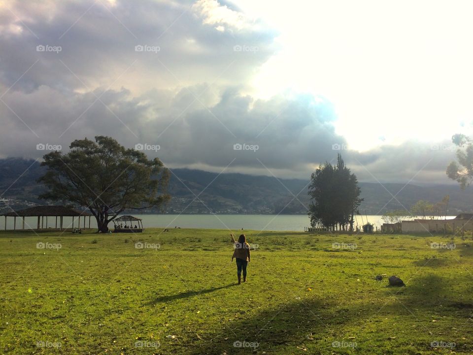 Woman on greenfield in front of a lake