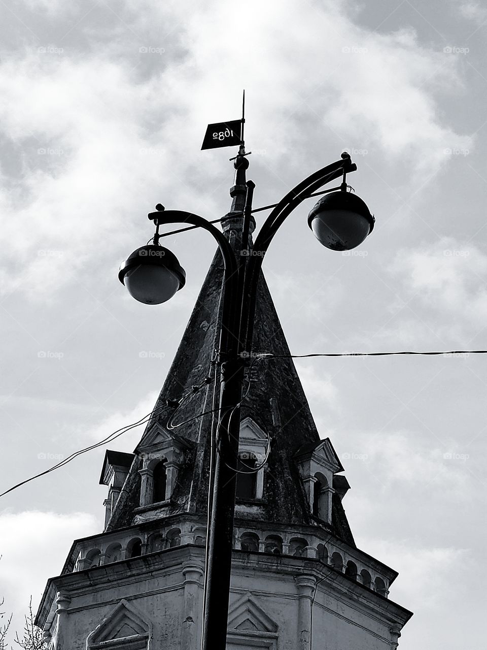 The dome of an old tower; in the foreground is a lantern with two round shades