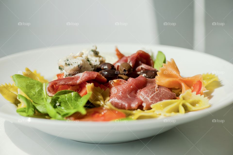 close-up of a young man eating a salad in a light kitchen