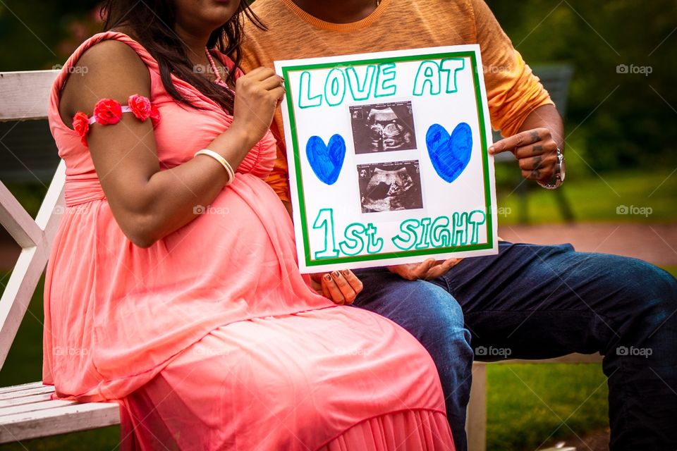 Indian couple showing ultra sonogram picture of their babies and celebrating pregnancy 