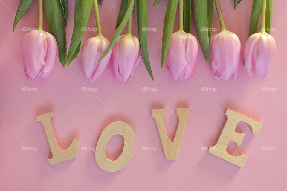 pink tulips with love letters on a wooden background