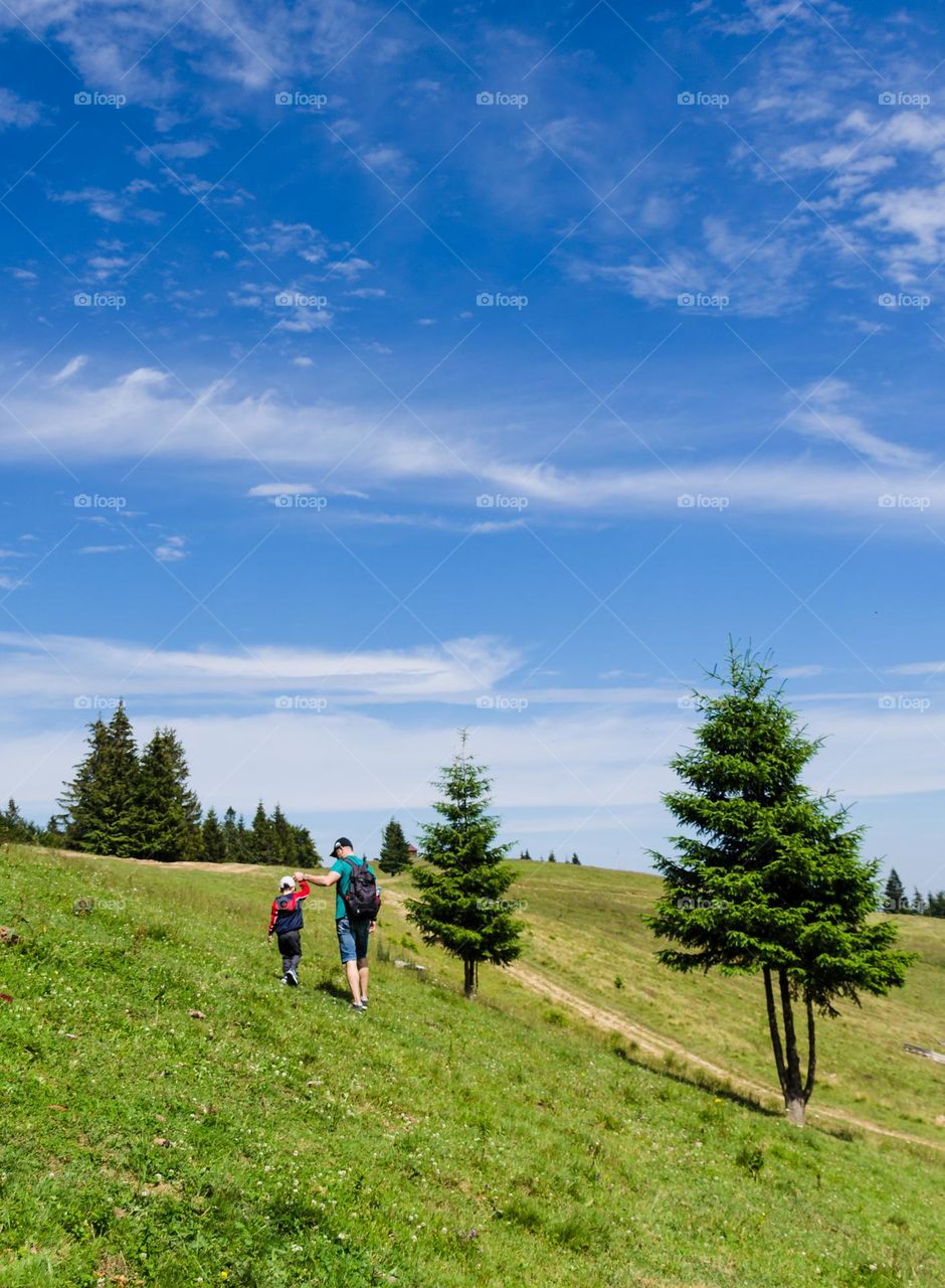Father with son walking in the Carpathian mountains