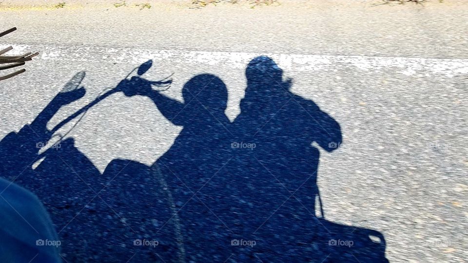 Silhouettes - Two people in silhouette riding on motorcycle. Monochromatic, B&W, shadow pic.