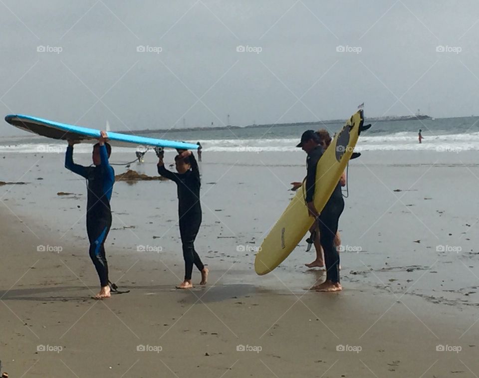 Three surfers on Venice Beach, California 