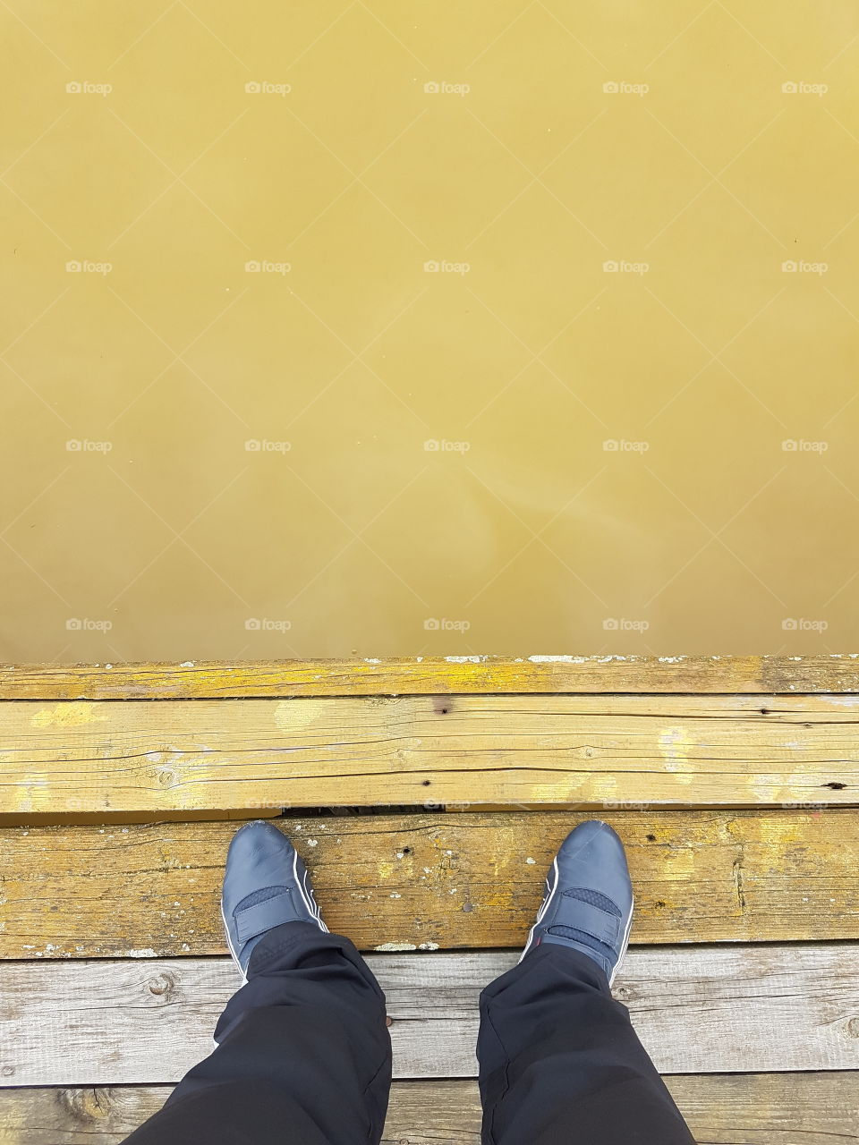 man standing on the edge of the lake dock