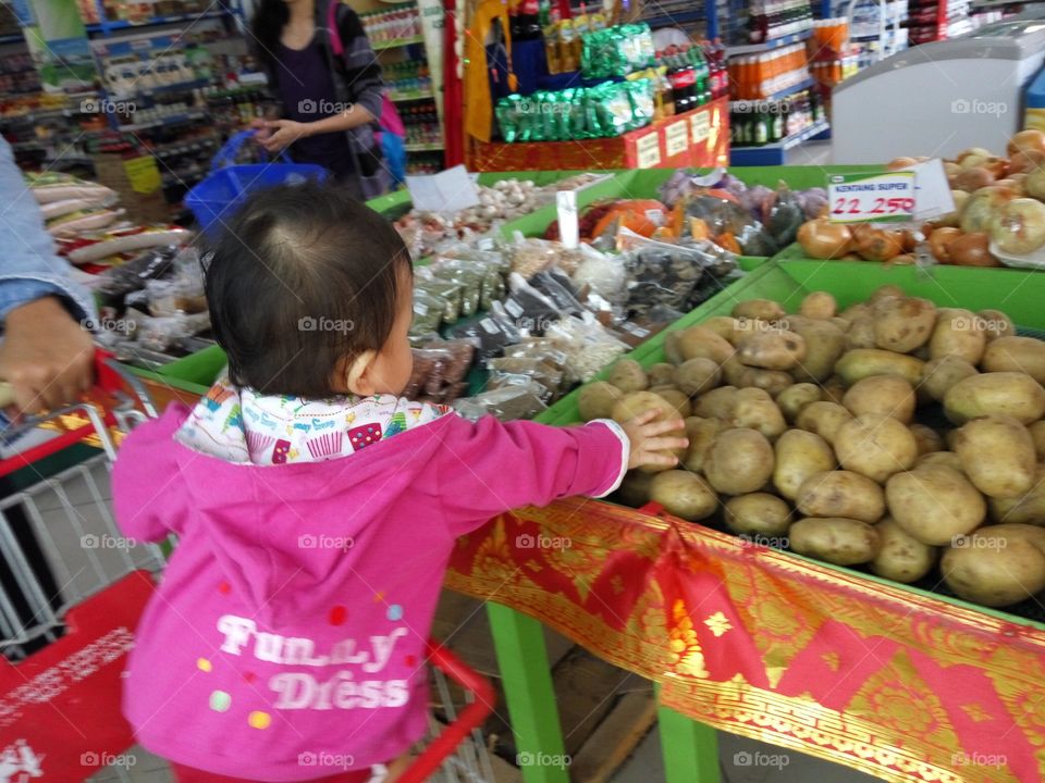 Baby learn how to shopping at the grocery store.